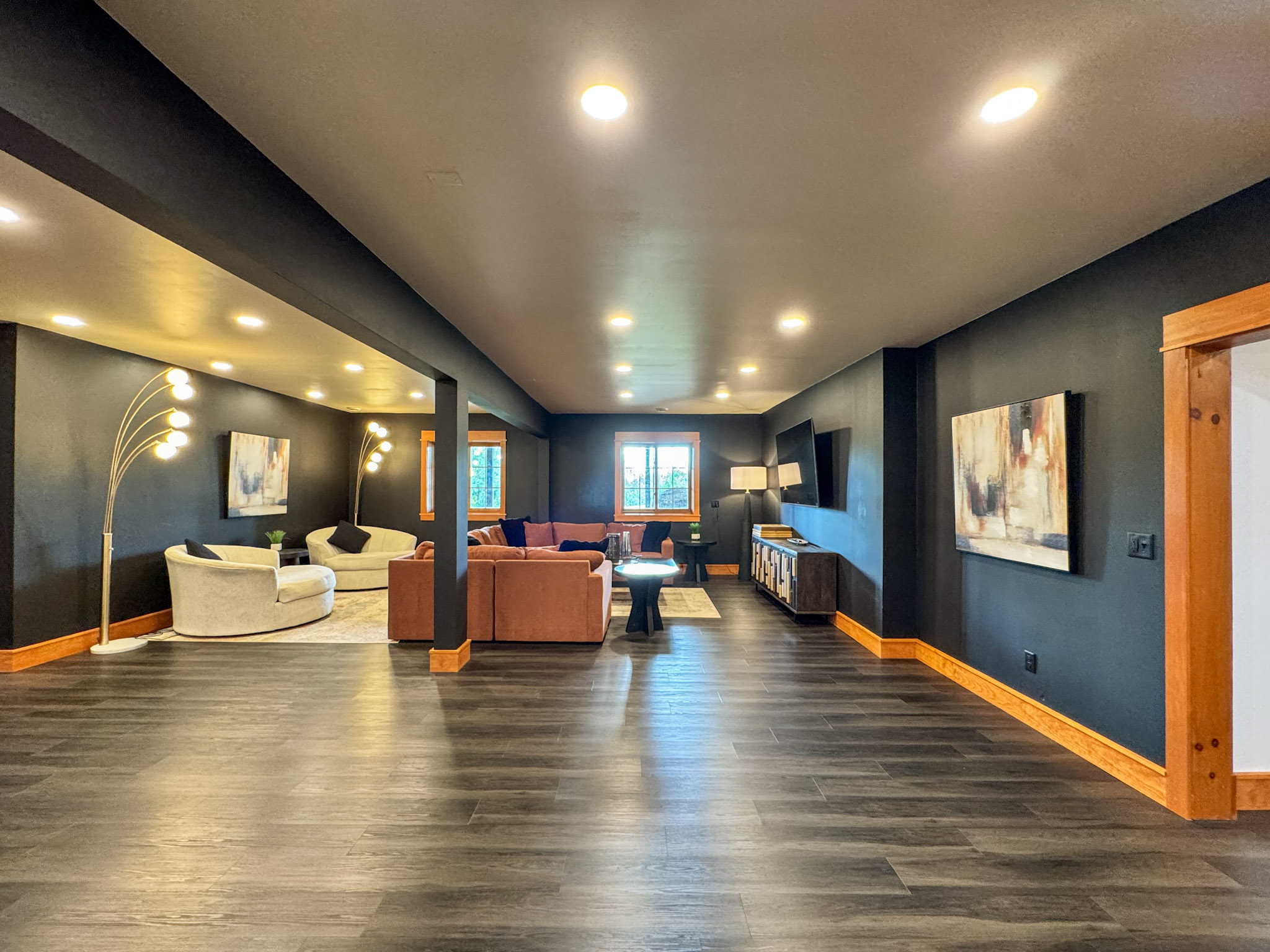 Downstairs living area with multiple seating areas and a large TV.