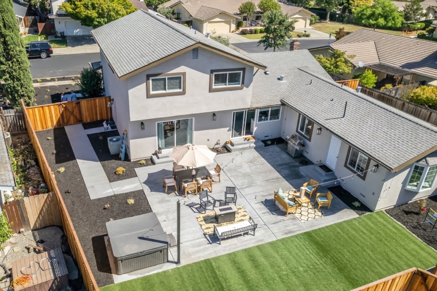 Backyard with hot tub and outdoor dining and seating with fire pit