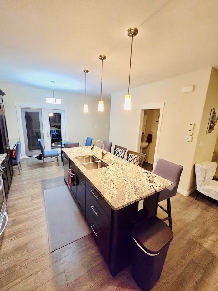 Stylish kitchen with granite island, bar seating, and patio-access dining nook