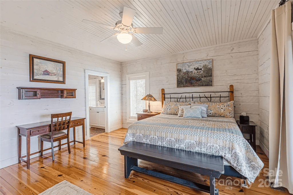 Charming Bedroom Retreat: Sunlit space with rustic wood floors and serene decor invites relaxation!