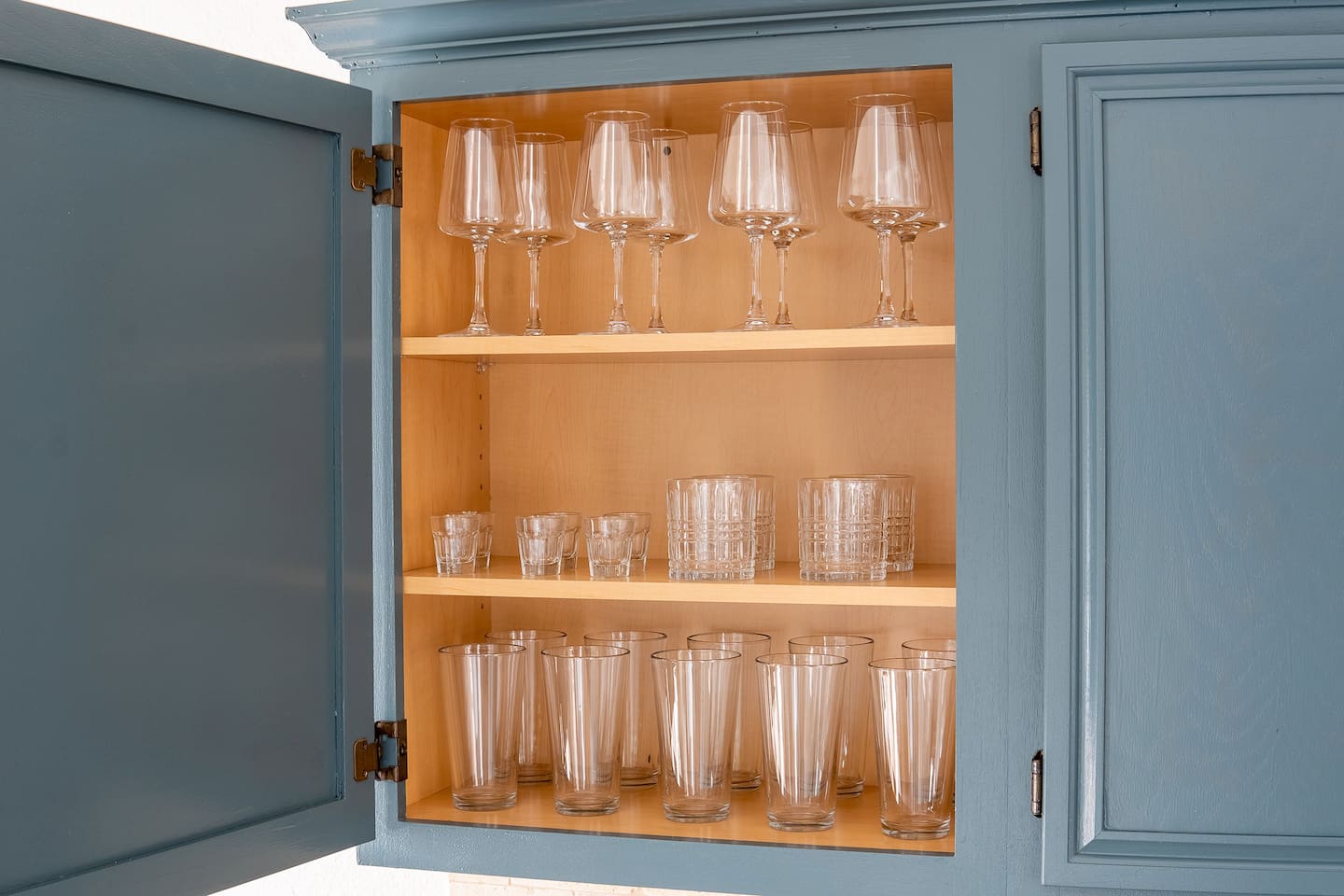 Indulge in culinary delight with a fully equipped kitchen adorned with essential tools and elegant wine glasses, where every meal becomes a masterpiece.