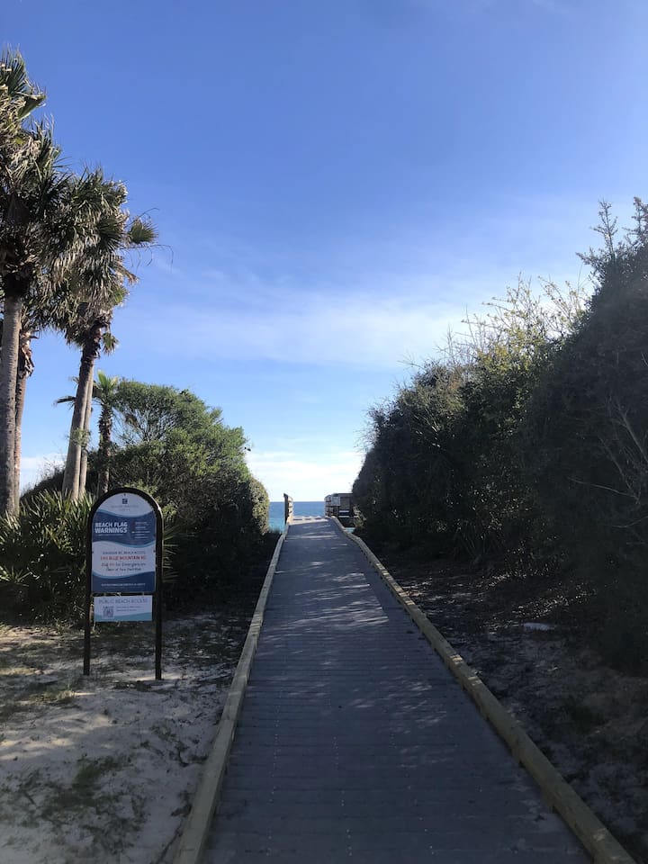 Discover a local secret!  A short stroll down Blue Mountain Rd leads to a more secluded public beach access. Enjoy a scenic coastal walkway lined with palms, leading to a quiet, peaceful stretch of sand—perfect for sunset walks.