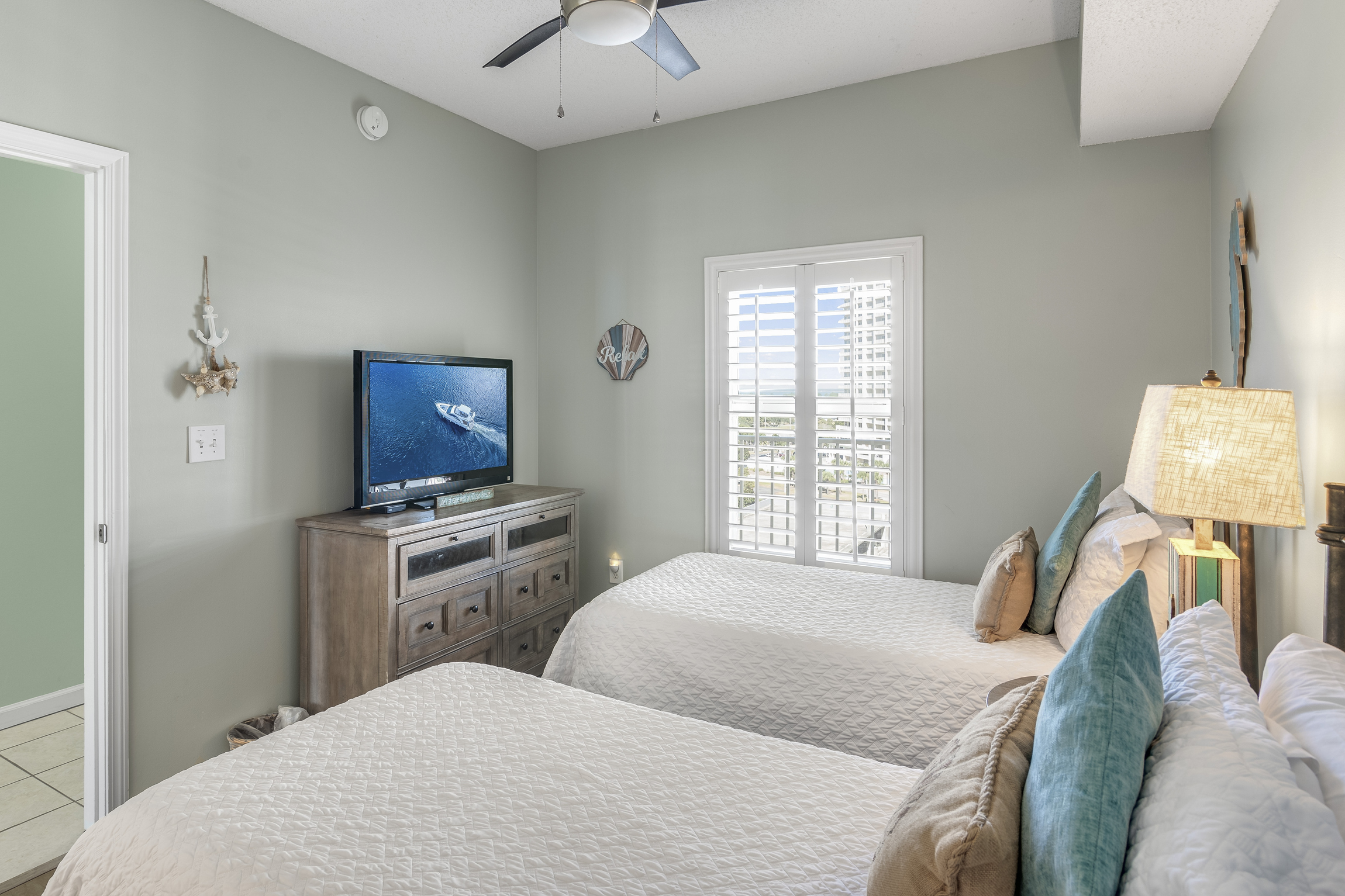 Guest Bedroom has two Twin Beds, TV, attached closet, and attached bathroom with shower/tub combo