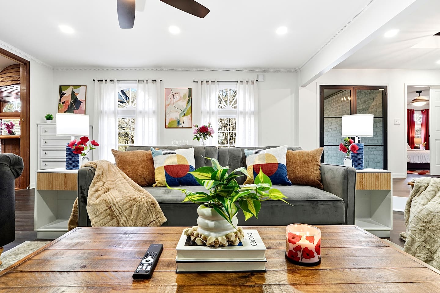 Warm and welcoming living room with two comfortable couches, two chairs, indoor plants, a cozy fireplace, and a TV powered by Google TV. Conveniently located as you walk through the front door and straight ahead from the primary side entrance. 