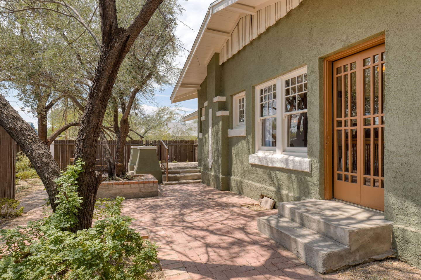private side yard with seating under trees, Olive and Mesquite