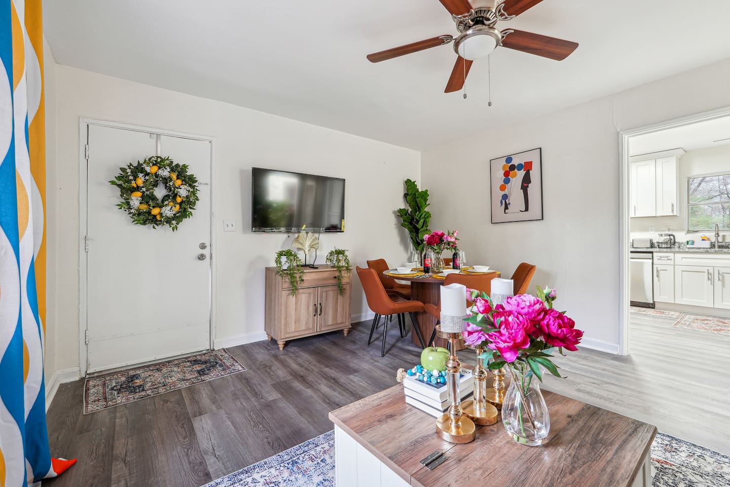 Enjoy a warm and inviting dining area combined with the living room, featuring a dining table set where you can enjoy meals while watching TV. The space also includes a ceiling fan for extra comfort and a cozy atmosphere for gathering and relaxing.
