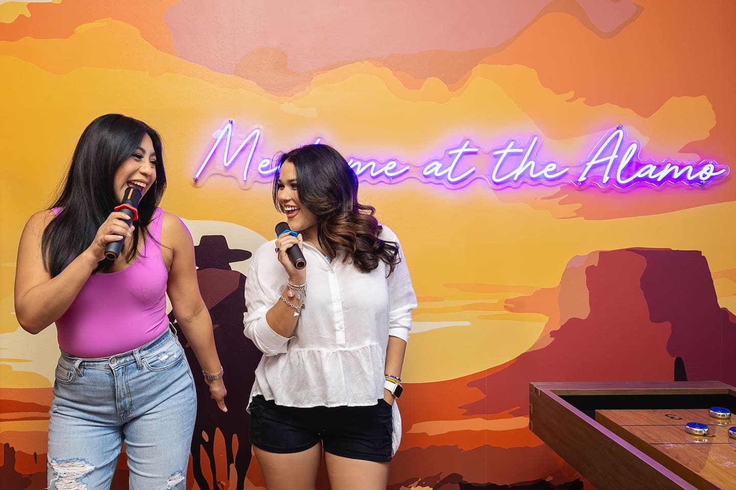 Let loose with your friends in this vibrant karaoke spot! Sing together under the "Meet me at the Alamo" sign, making memories, sharing laughs, and having an unforgettable time. Perfect for friends seeking a fun, music-filled night!