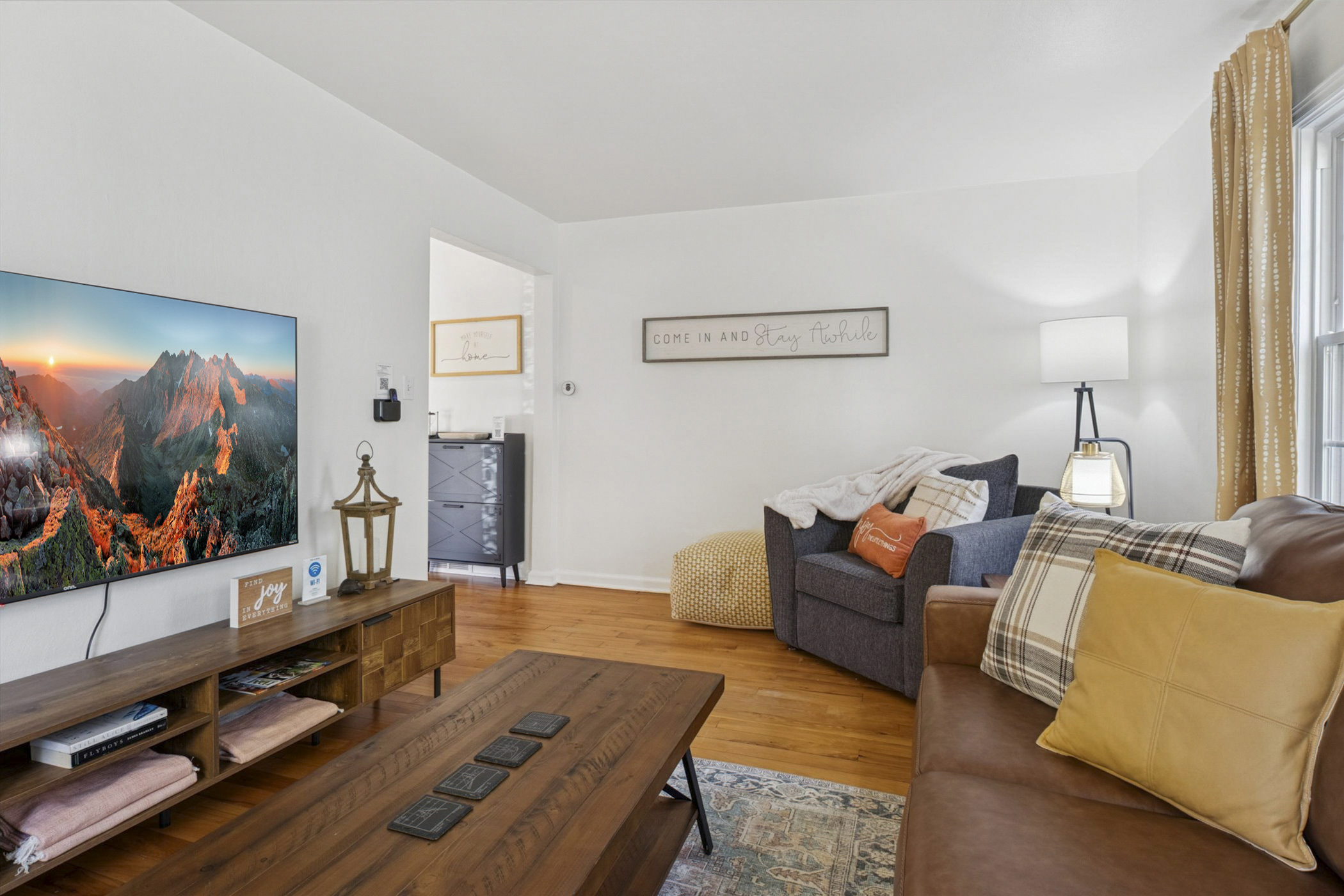 Comfort meets charm—our South Bend guest retreat living room features plush seating, cozy blankets, pillows, coasters, and a smart TV. A perfect spot to relax near Notre Dame.