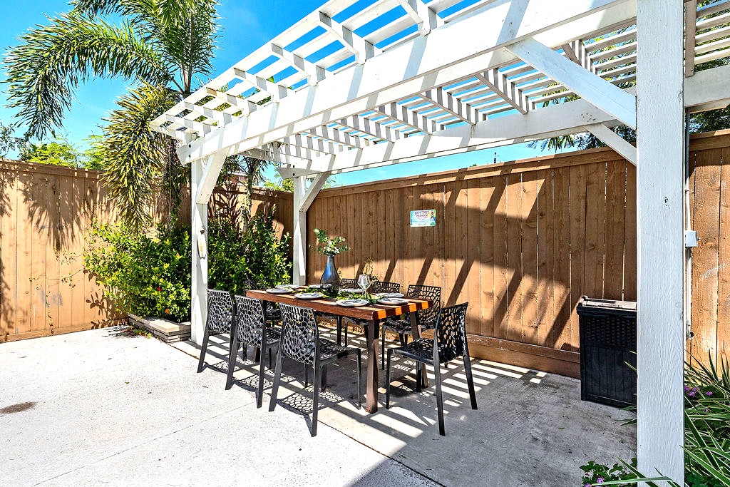 Relax and dine in comfort beneath the shade, with the poolside glow and palm-lined backdrop creating a serene space for connection and conversation.