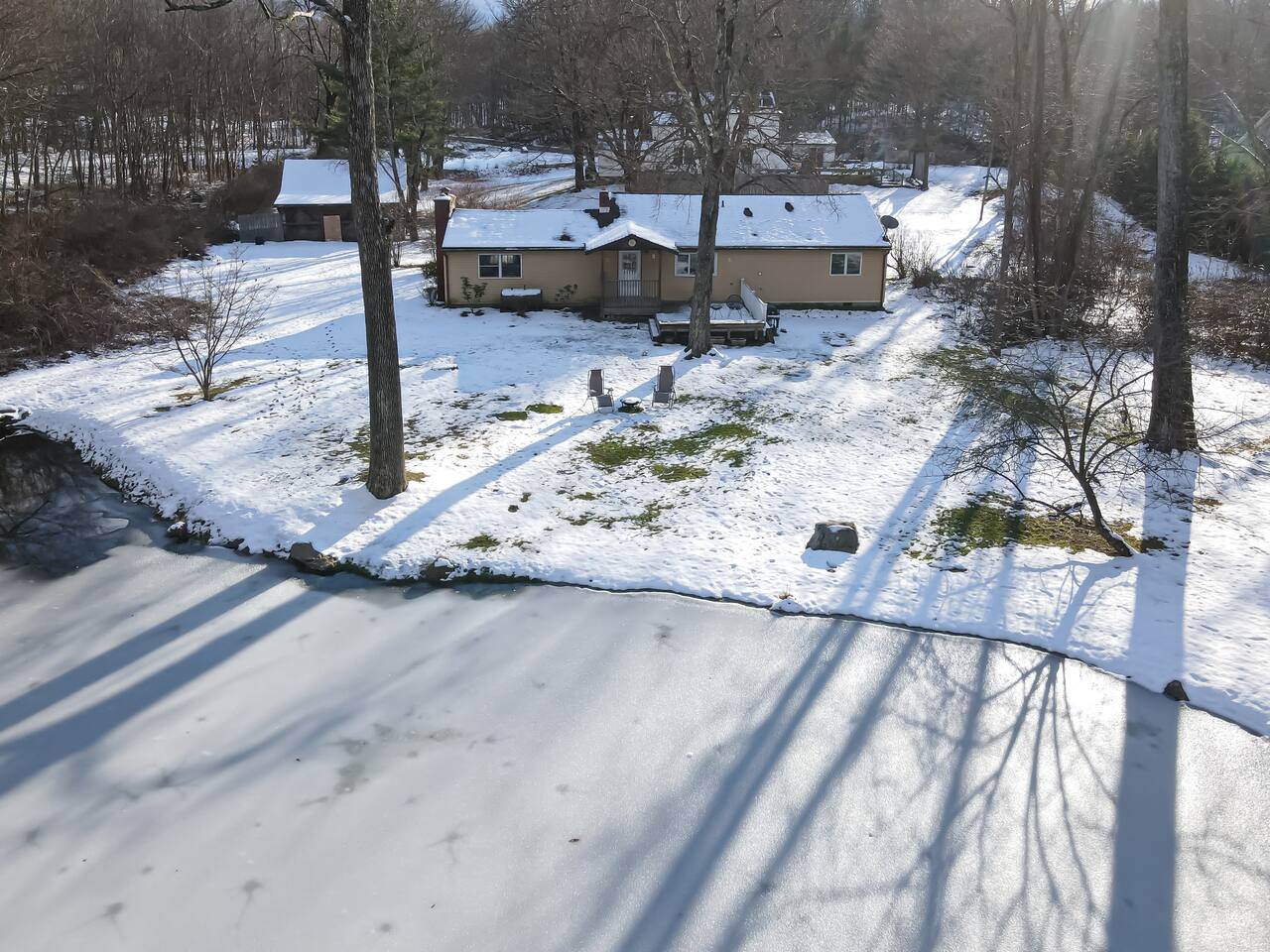 Backyard drone shot of house & pond.