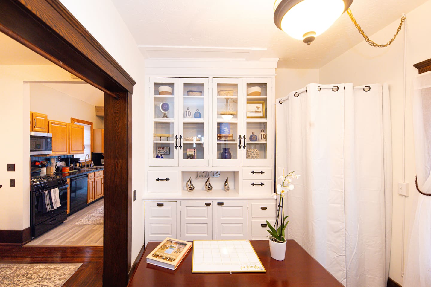 The "office" area has a desk, USB ports, games & books in the cabinets & hidden behind the curtain is a stackable washer/dryer!