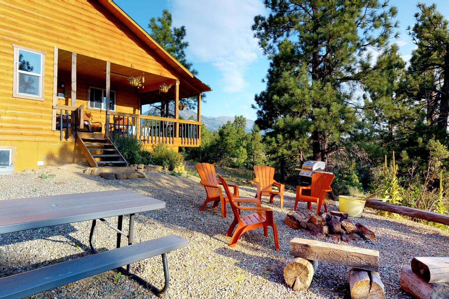 A picnic area and fire pit are located behind the cabin.