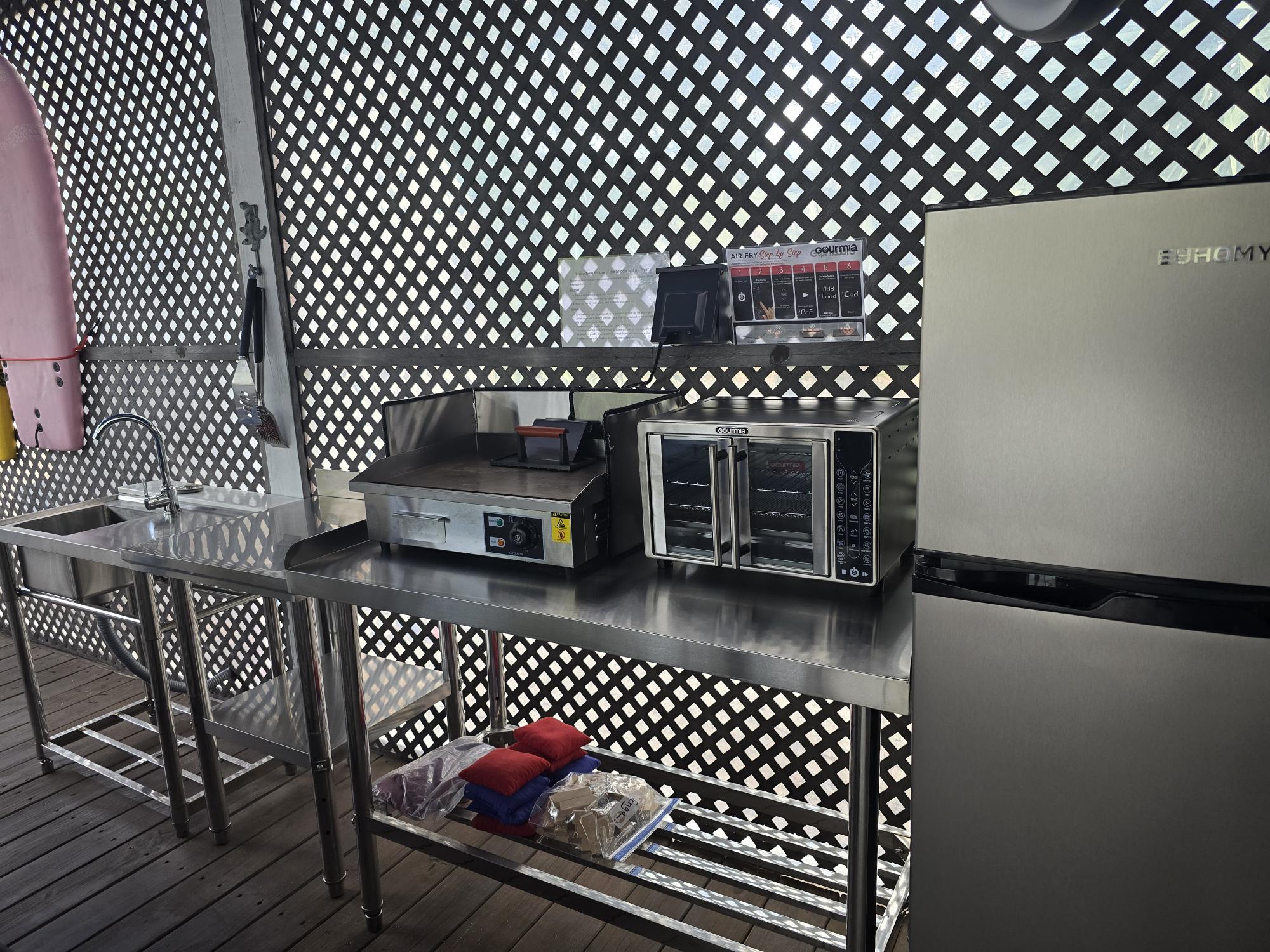 Refrigerator, griddle, air fryer, sink and counterspace in the Patio Kitchen