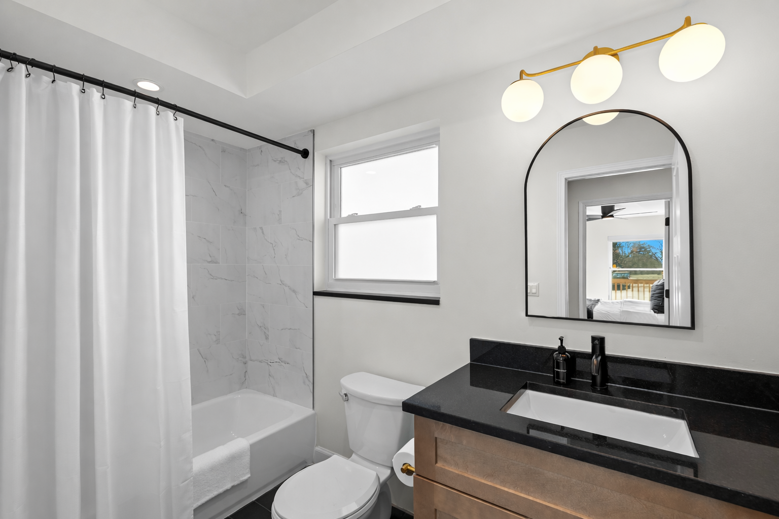 Clean, modern bathroom with a tub-shower combo, sleek vanity, and bright lighting—fresh, functional, and designed for everyday comfort.