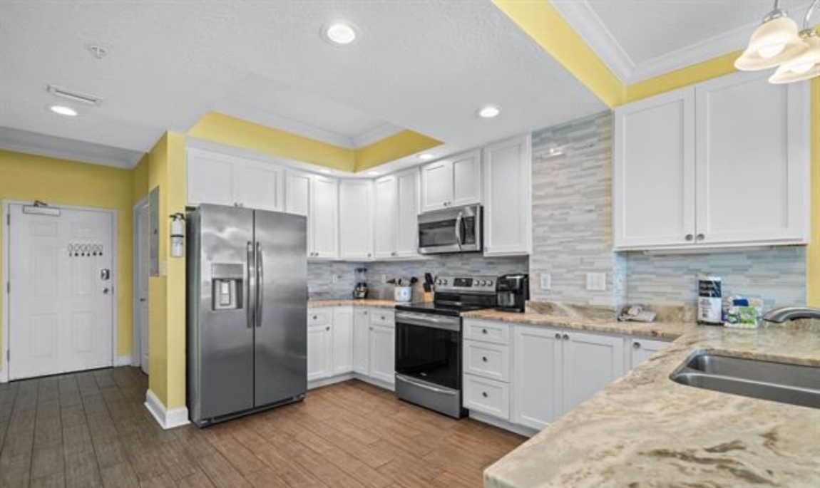ENLARGED kitchen with stainless steel appliances (electric range, above range microwave, dishwasher, fridge with ice maker, solid wood cabinets, granite countertops and tiled backsplash