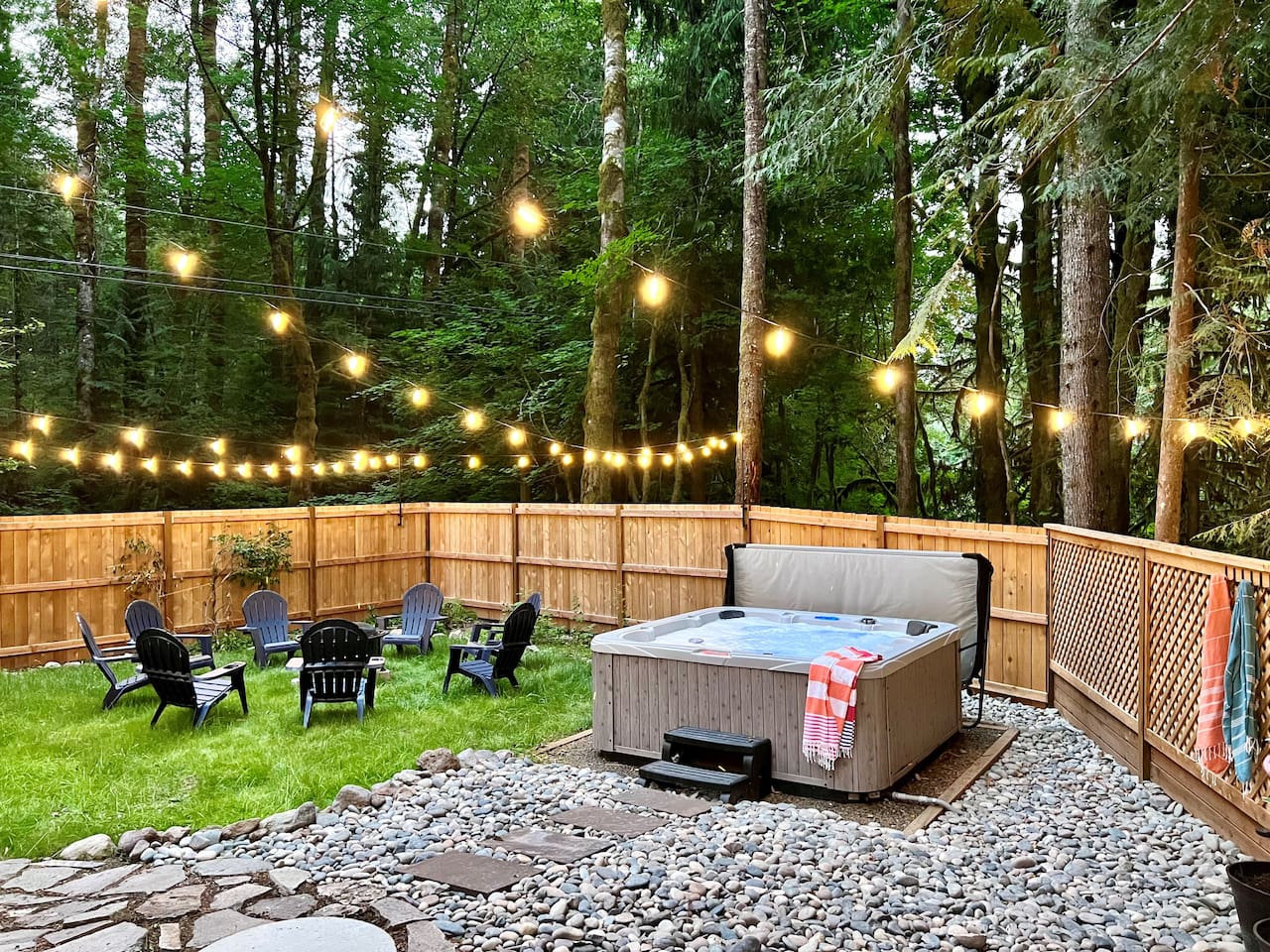 Gated side yard with privacy fence, hot tub and seasonal firepit.