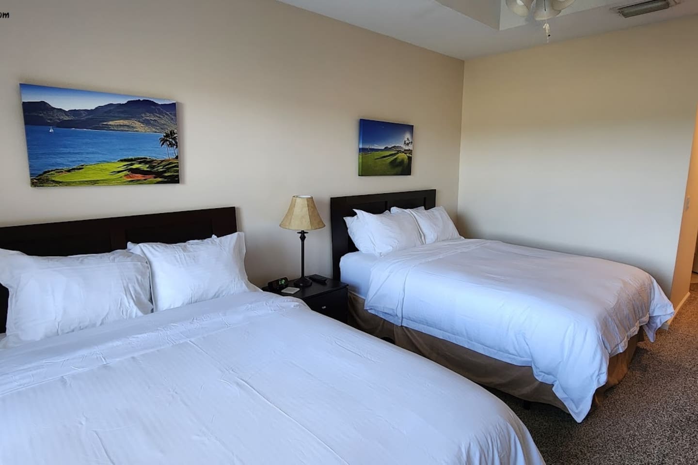 Comfortable bedroom with two beds, ceiling fan, and a relaxing setup for guests or family stays.