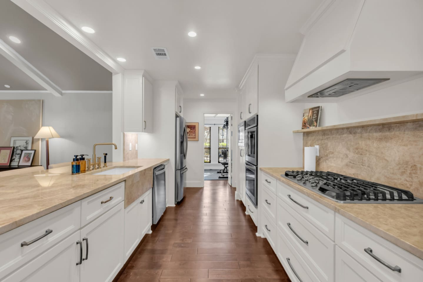 Spacious kitchen with granite countertops, gas stove, double oven, dishwasher, oversized sink, and a refrigerator, complete with all cooking essentials for effortless meals.