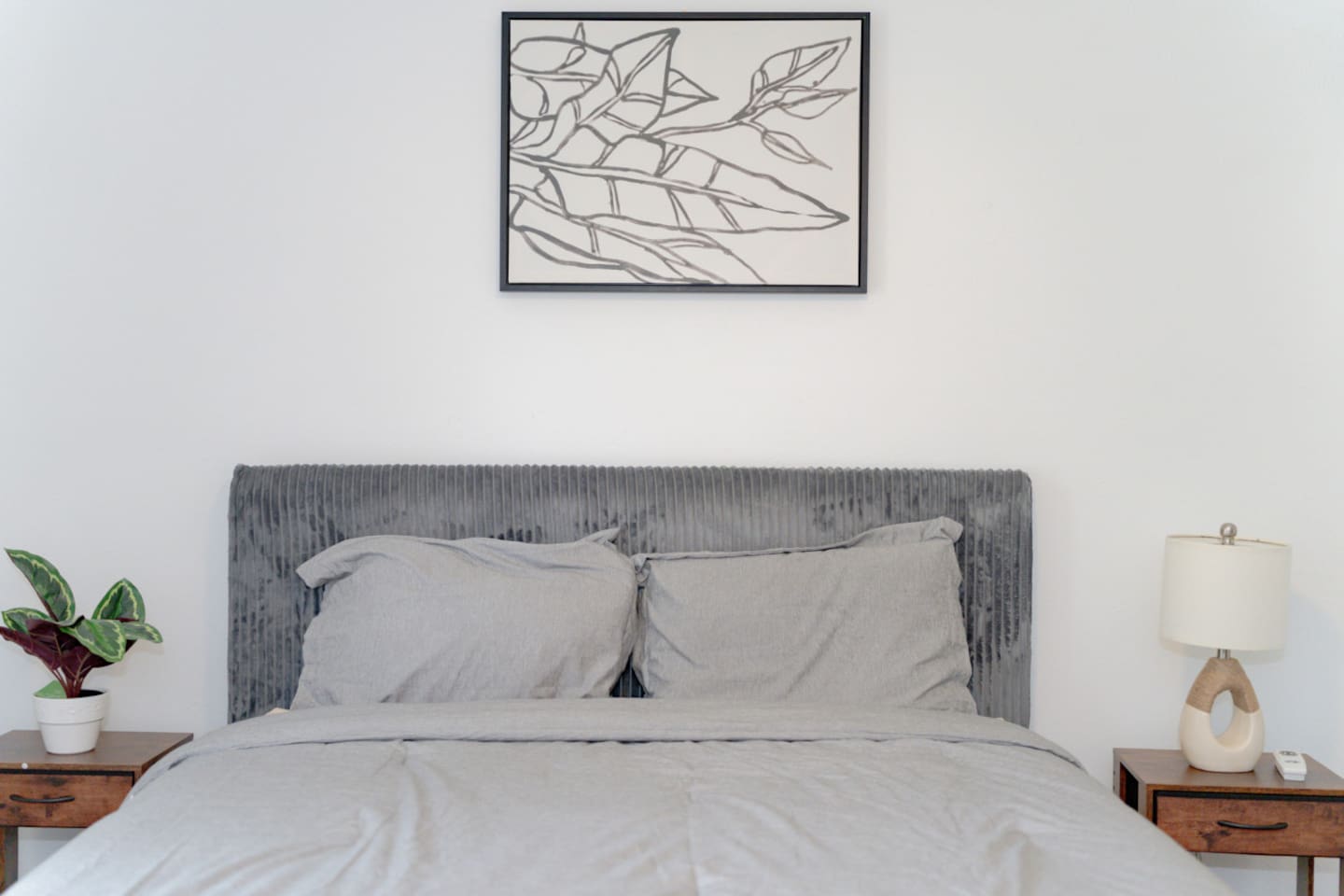Bedroom view with upholstered bed and warm natural tones.