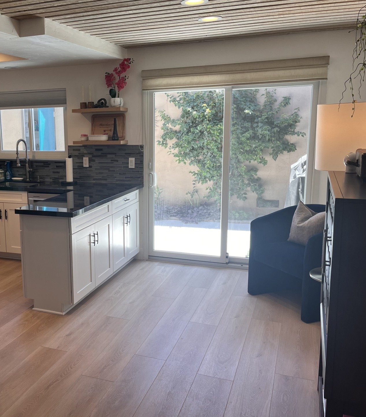 Lounge area includes dry bar and easy access to the courtyard with outdoor table and gas grill.
