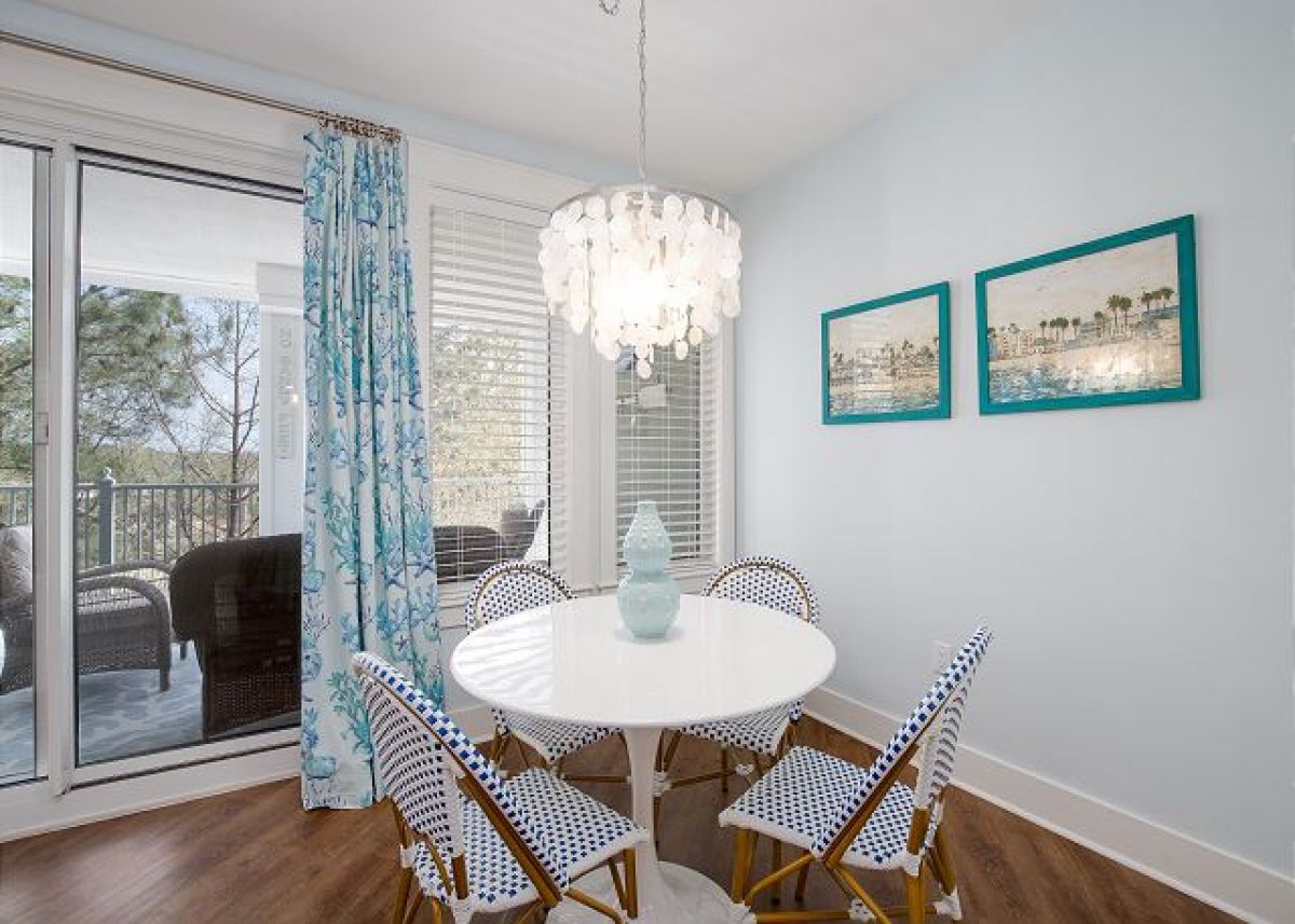 Dining table for four with capiz chandelier next to the sliding doors to the balcony