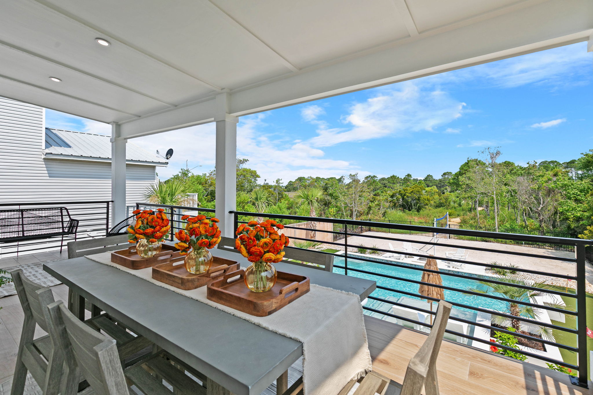 Enjoy meals and morning coffee on the covered balcony overlooking the private pool and backyard.