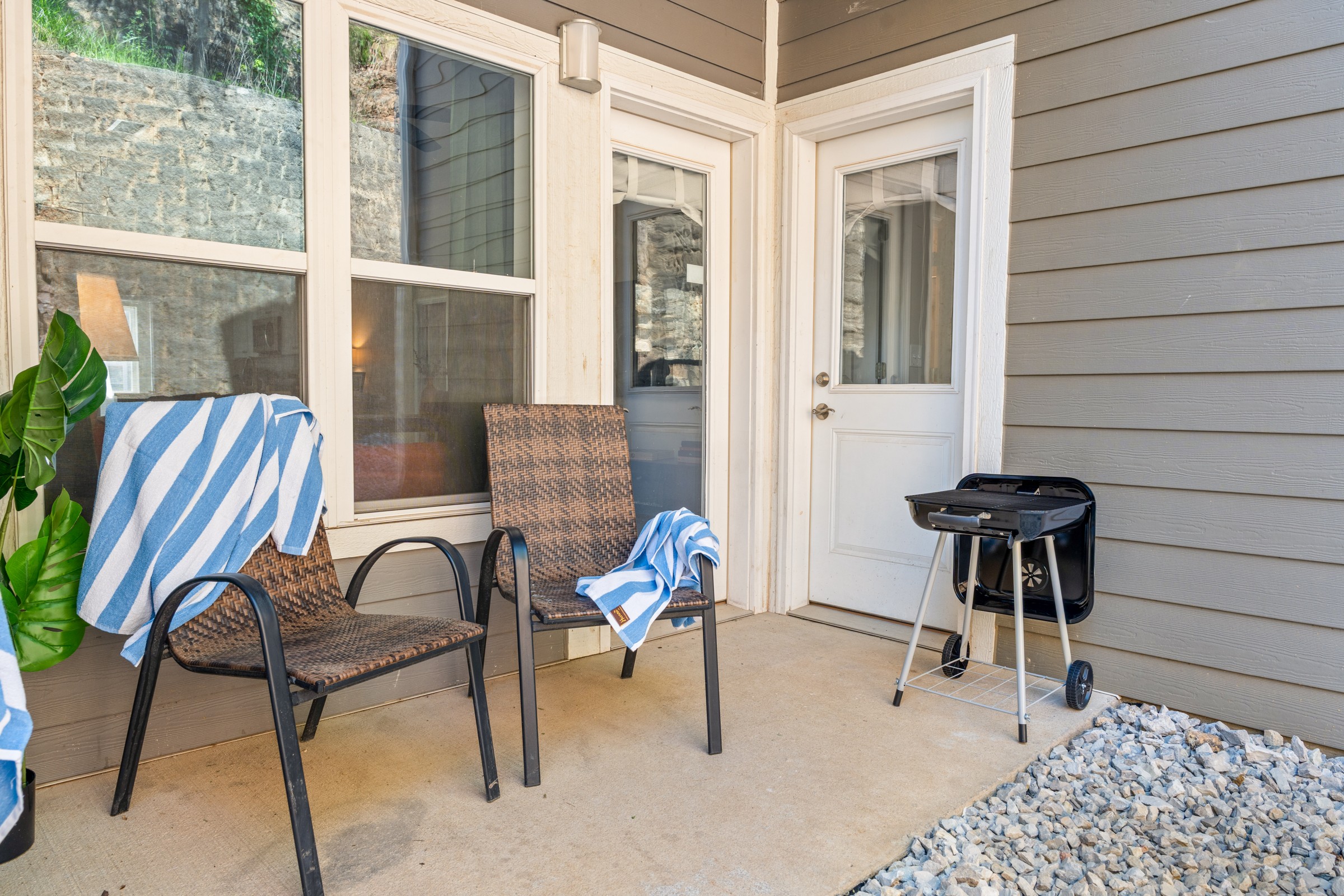 Private patio with two chairs and a charcoal grill by the door. Fire up dinner and enjoy it outside, just a step from the kitchen.