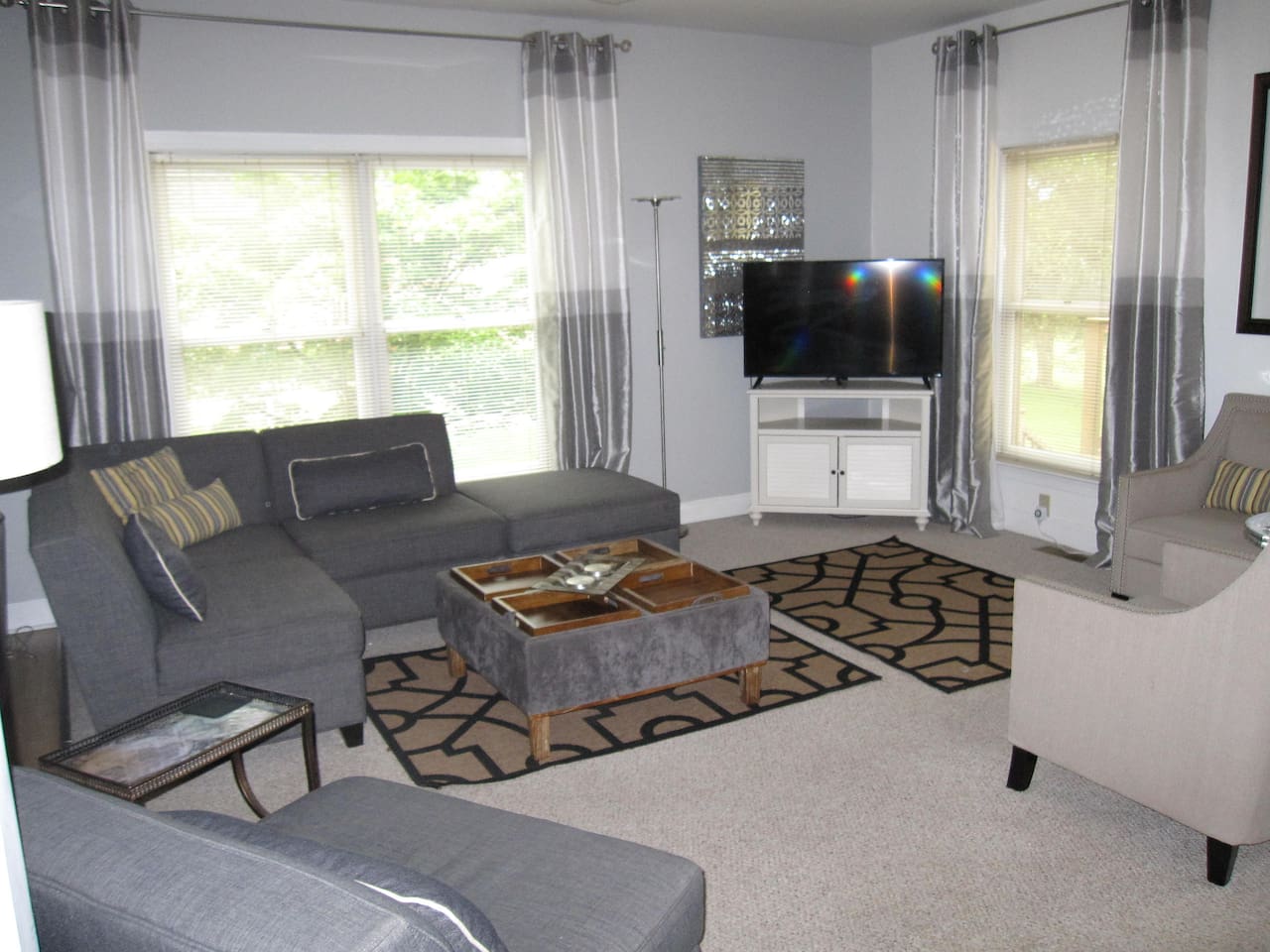 Far end of living room opposite the house entrance, sectional chairs and one of the TV's. 