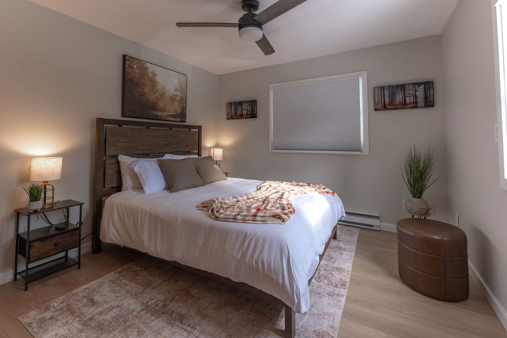 Main level bedroom with a queen sized mattress and side tables. 
