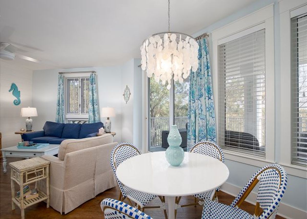 Dining nook with capiz shell chandelier and round table for four beside the living room
