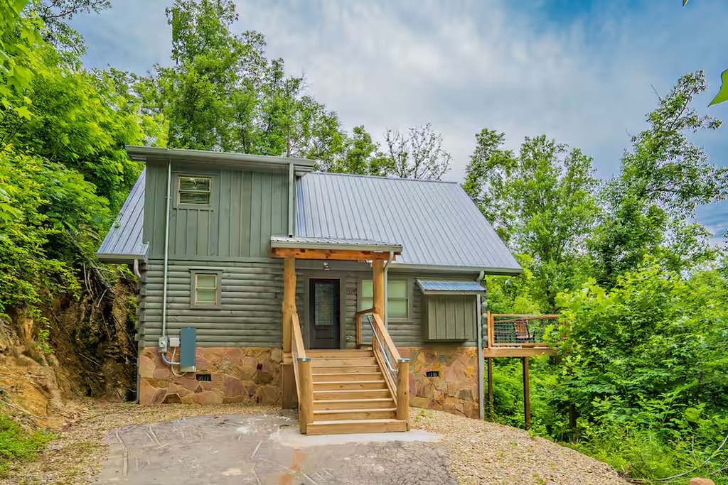 The front entrance of Bear Paws Cabin welcomes your family with classic Smoky Mountain log cabin charm &mdash; hand-hewn wood steps, stone foundation, and a durable metal roof built to weather every season. Located in Gatlinburg, Tennessee near Great Smoky Mount