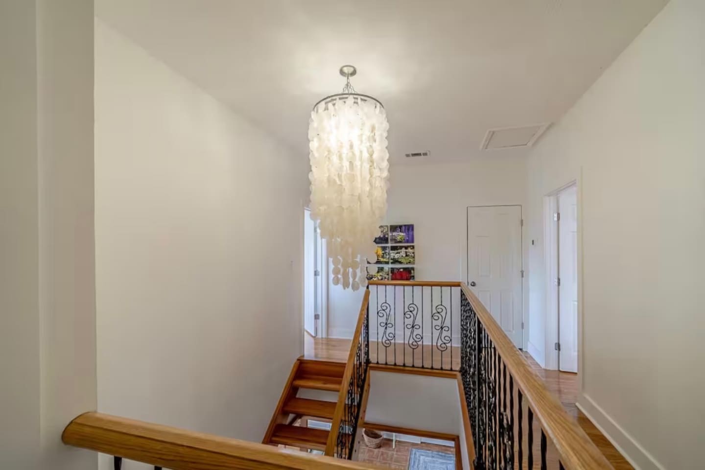 Spacious second-floor landing connecting the upper bedrooms and featuring a gorgeous modern chandelier