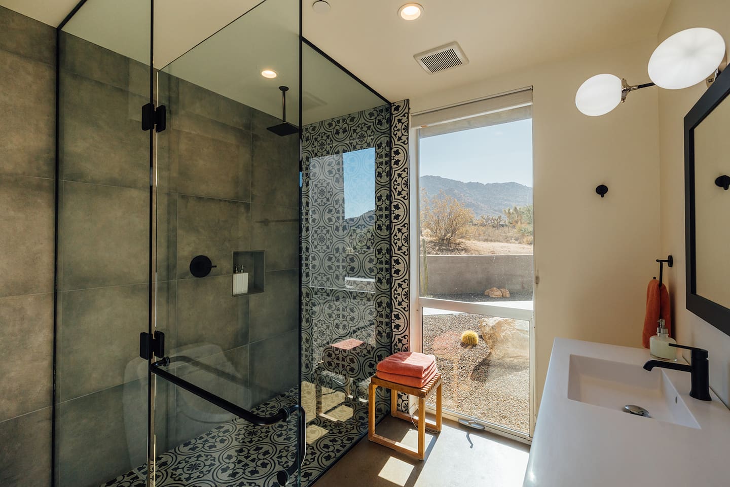 Modern master bathroom with outdoor views and rain shower.