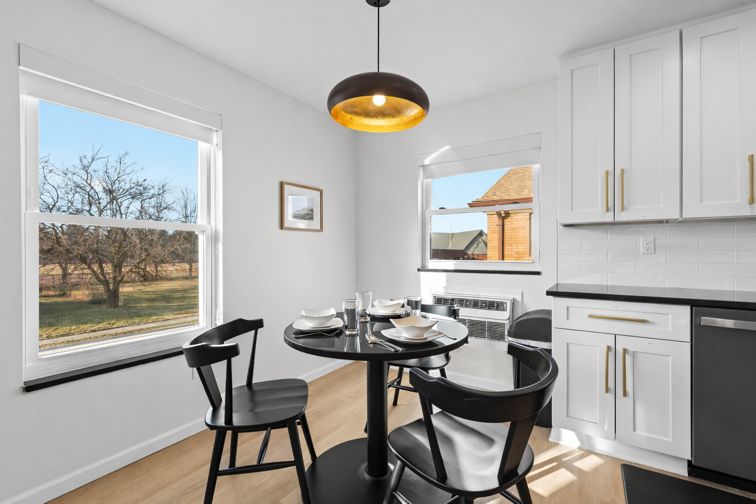 Bright, modern dining nook with sun-filled windows, sleek finishes, and a cozy table—perfect for morning coffee or intimate meals at home.