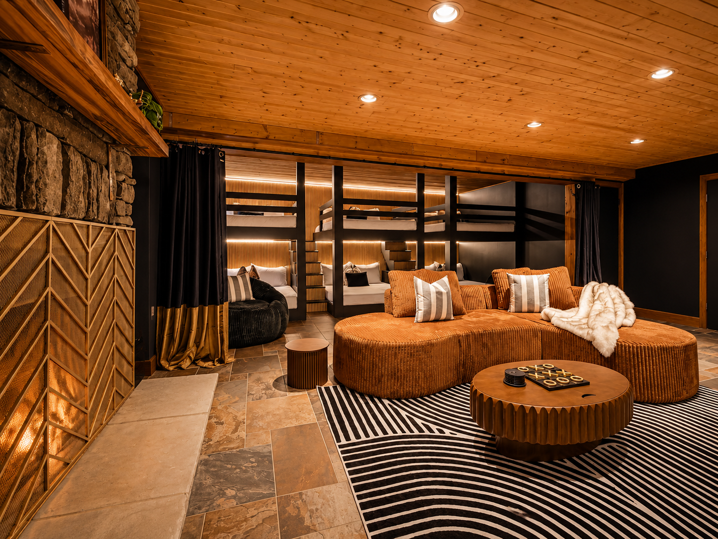 {Bunk Lounge} Three queen-over-queen bunks pair with a cozy fireside hangout space for families and larger groups.