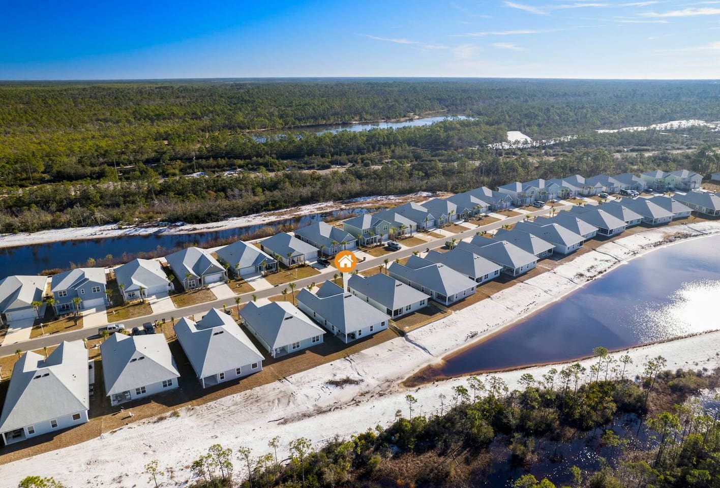 Aerial view of a peaceful coastal community surrounded by nature and water views.