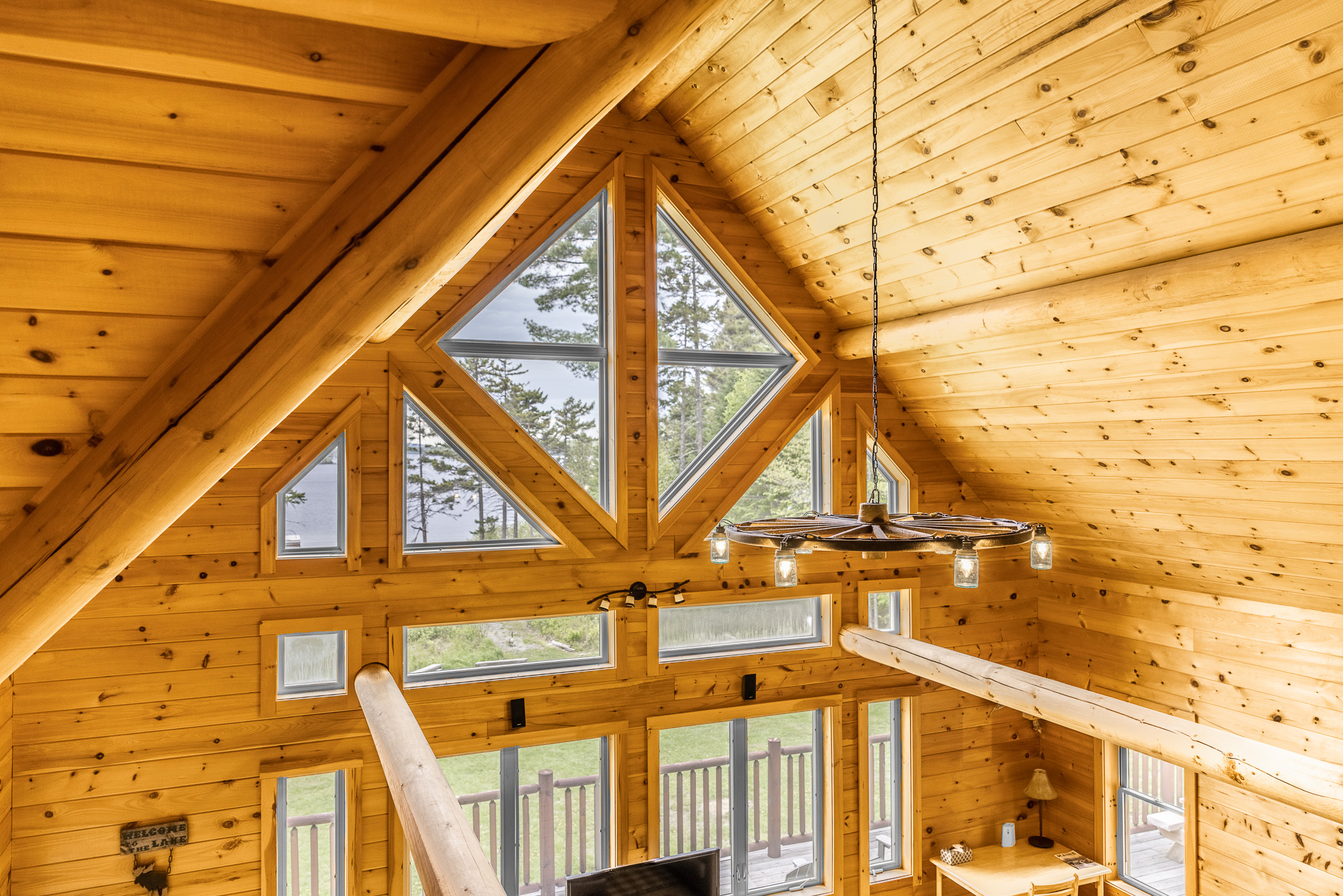 Chalet has huge logs and windows overlooking the lake giving it the true feel of lakefront retreat. Floor to ceiling wood-burning fireplace is impressive and great spot to enjoy the crackling sounds of fire anytime of the year while you relax.