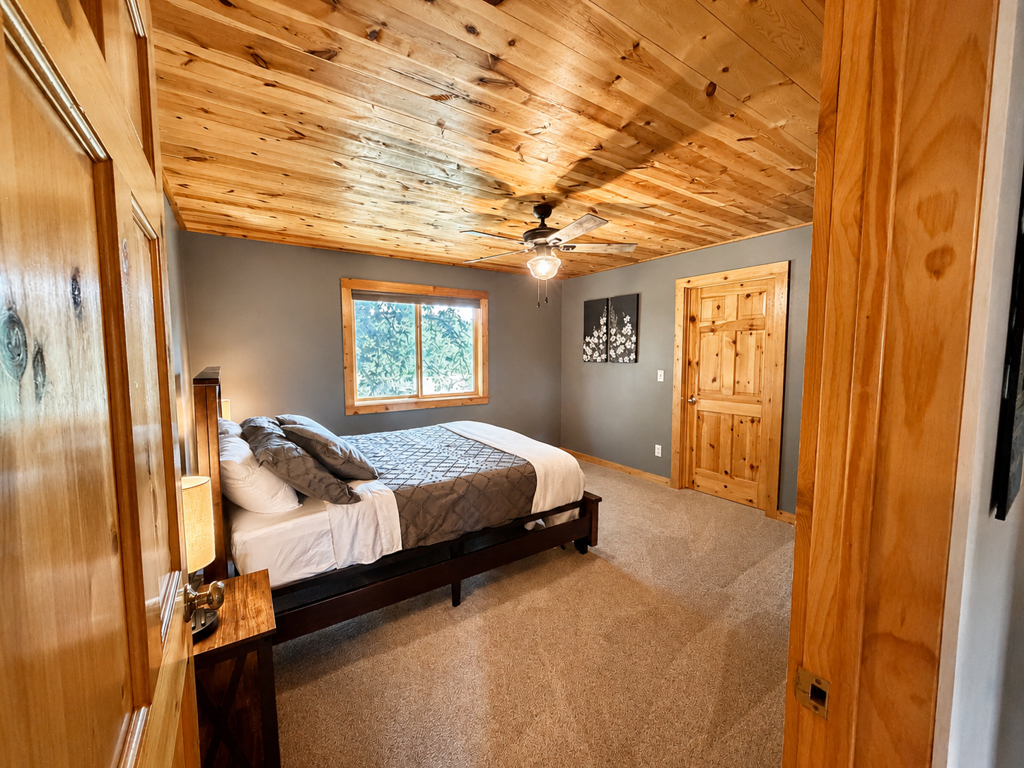 Warm wood ceilings and rustic finishes give this private bedroom a comfortable Northwoods feel. This spacious bedroom has a large walk in closet and room to spread out.