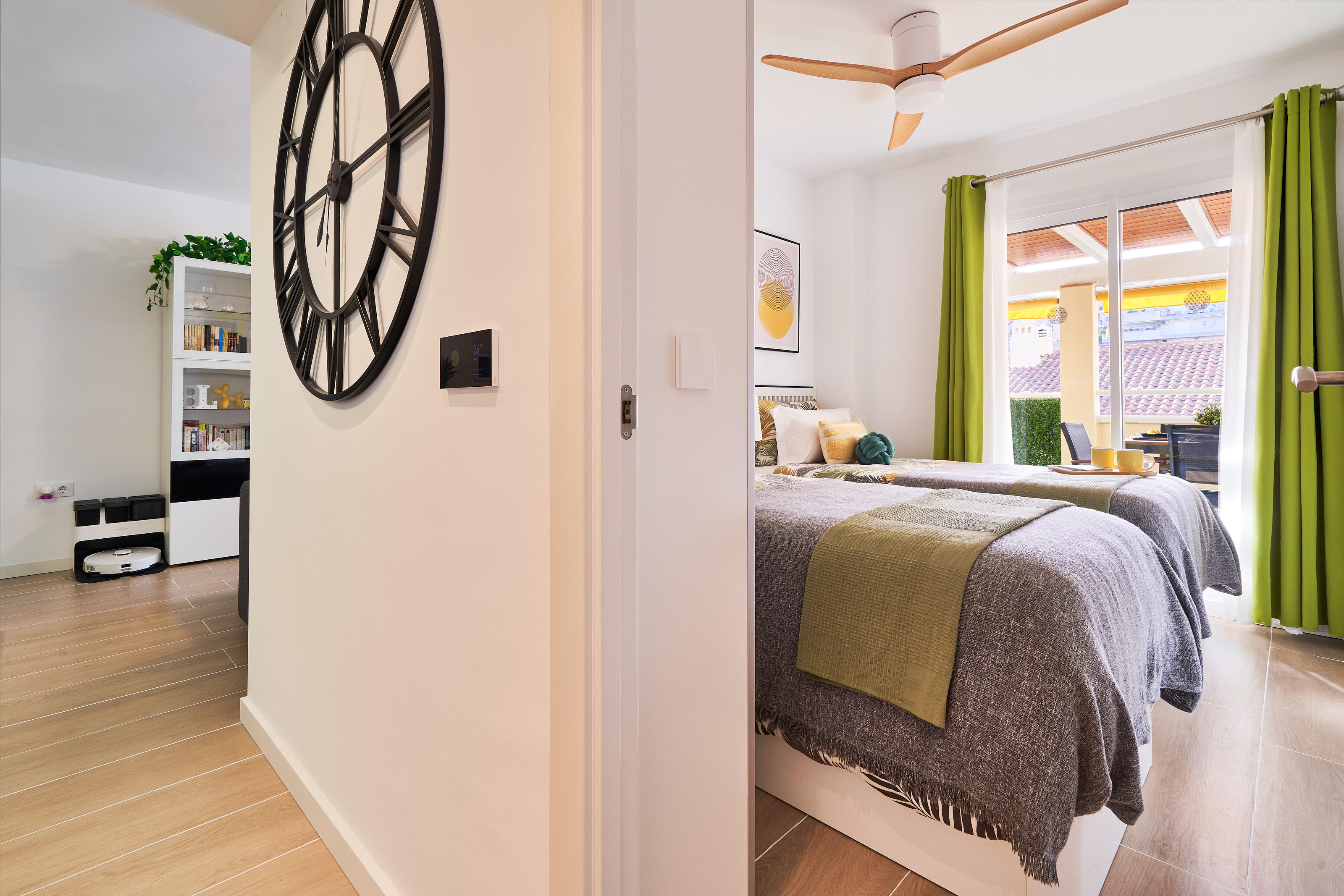 Bright and calming twin bedroom with tropical tones, soft linens, and direct access to the terrace — perfect for relaxed mornings and restful nights.