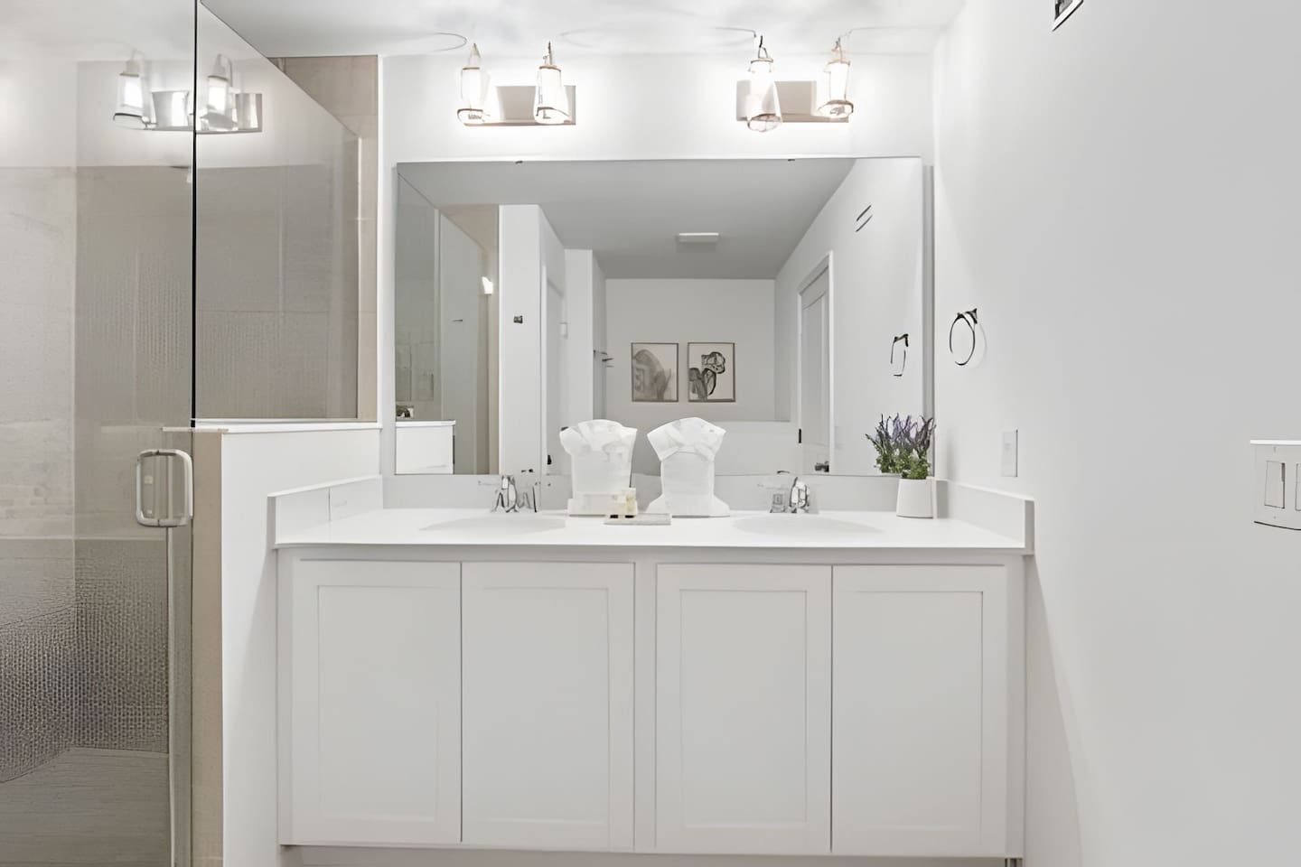 Fresh towels neatly prepared + eco-friendly shampoo and soap, along with a modern vanity space.
