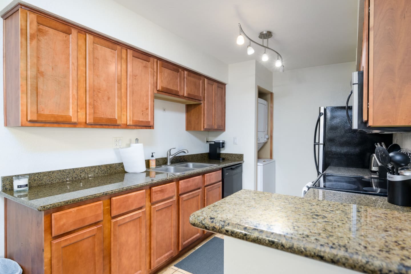 Kitchen setup with coffee maker, stove, microwave, refrigerator, and everyday cooking essentials.