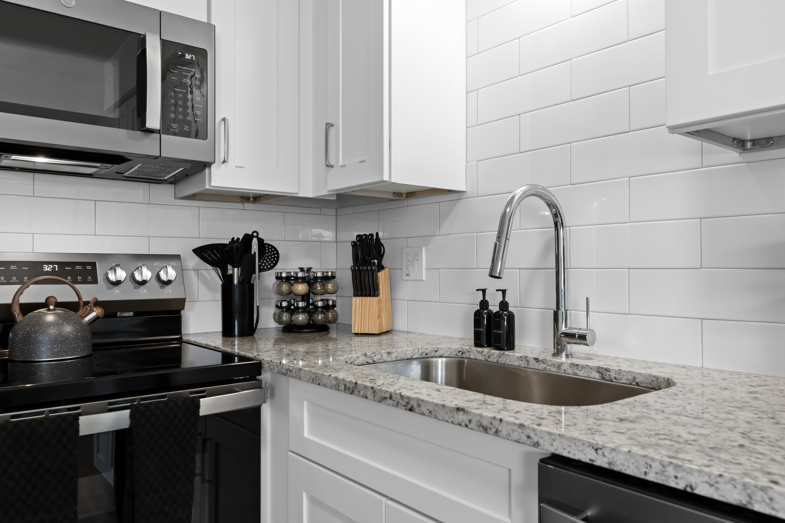 Bright and functional kitchen with granite counters, subway tile backsplash, and stainless steel appliances.