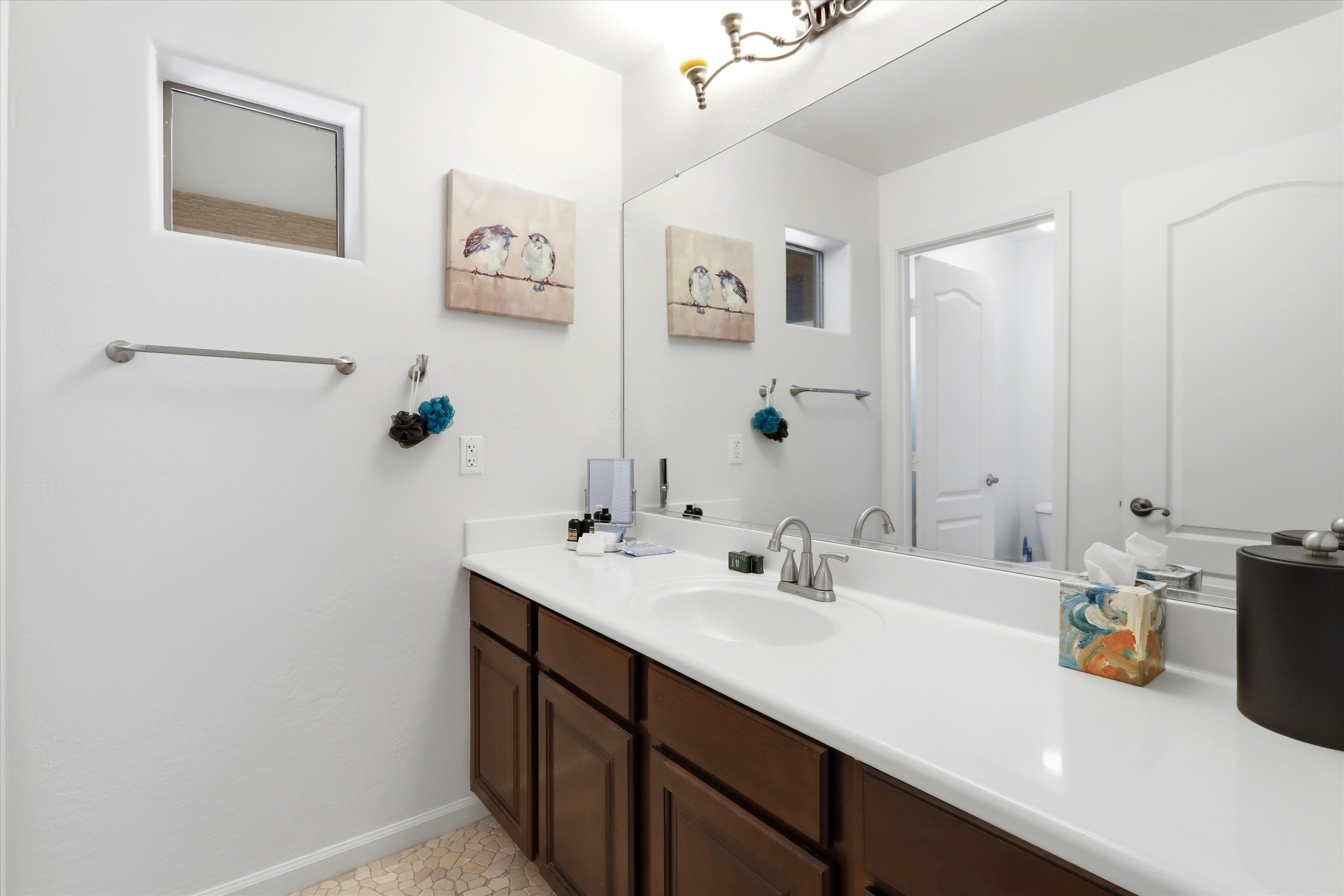 Bathroom vanity with a wide counter, storage cabinets, and space for getting ready.
