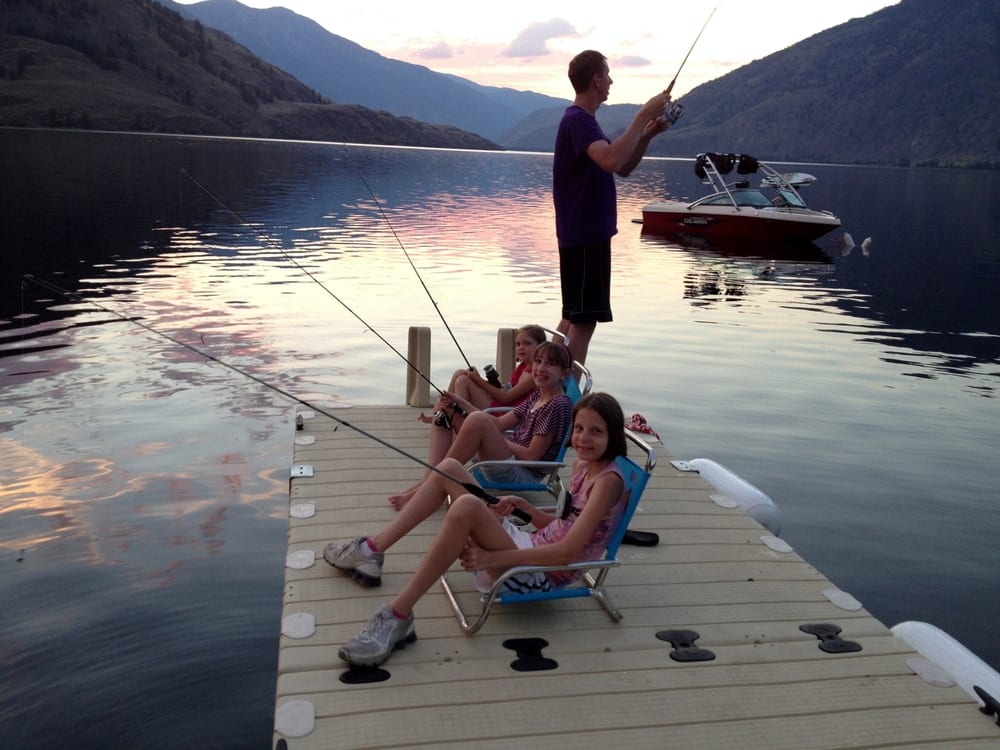 Family fishing and sitting on the dock at sunset