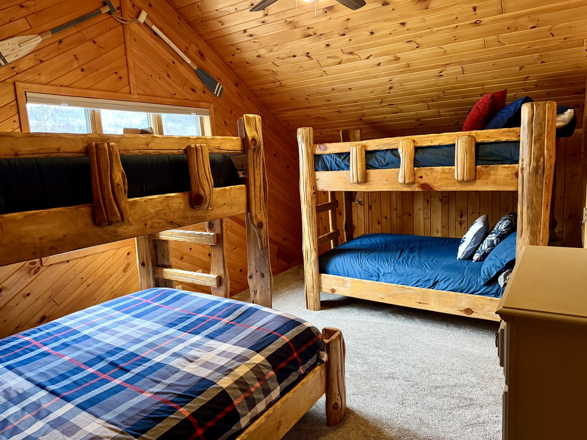 Upstairs bunk room with two bunk beds and a dresser, an awesome setup for kids, cousins, or the whole crew to crash comfortably after a full day of North Shore adventures.