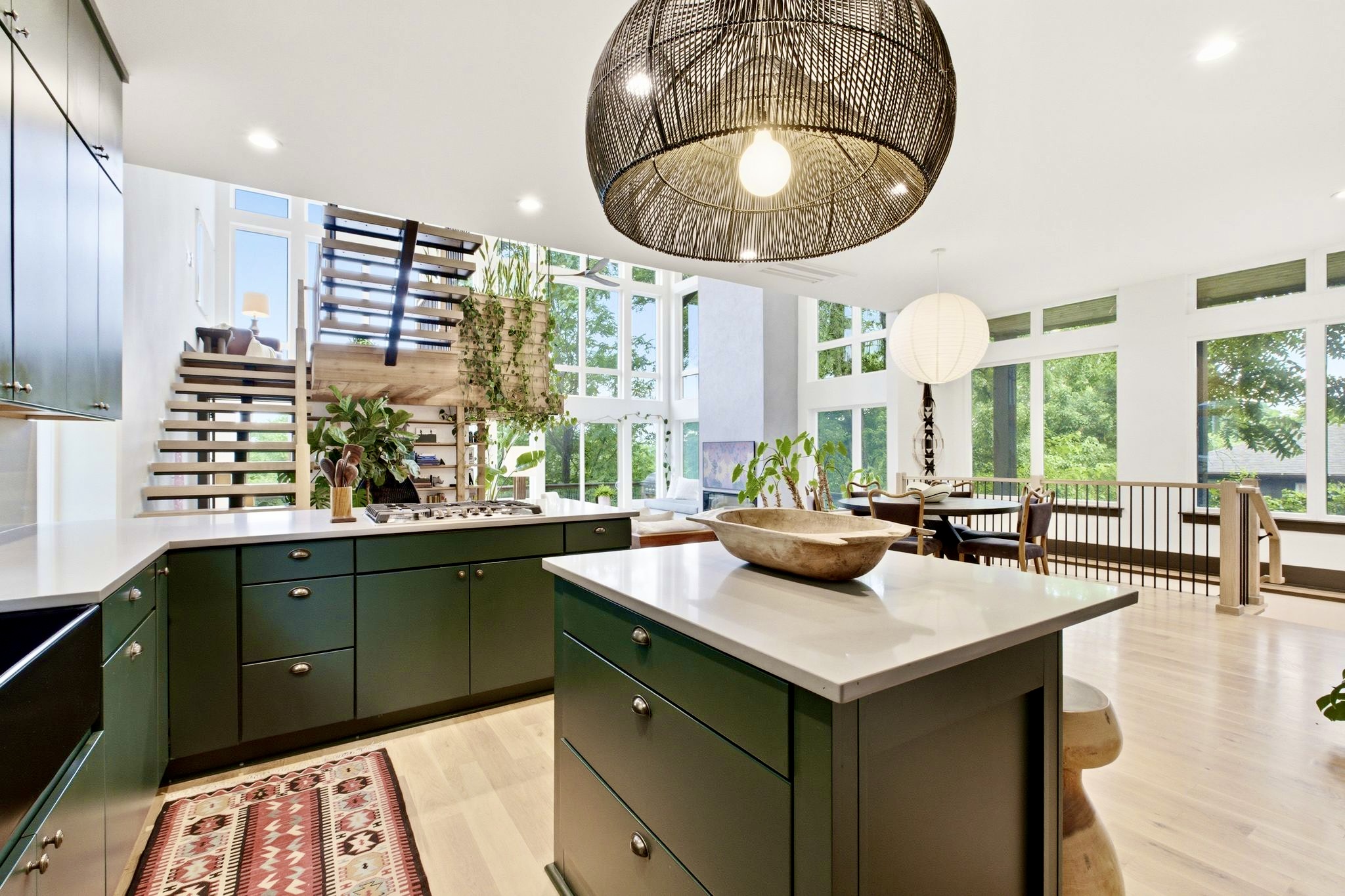 Showstopping kitchen w/ deep green island, statement pendant & plenty of prep space.
