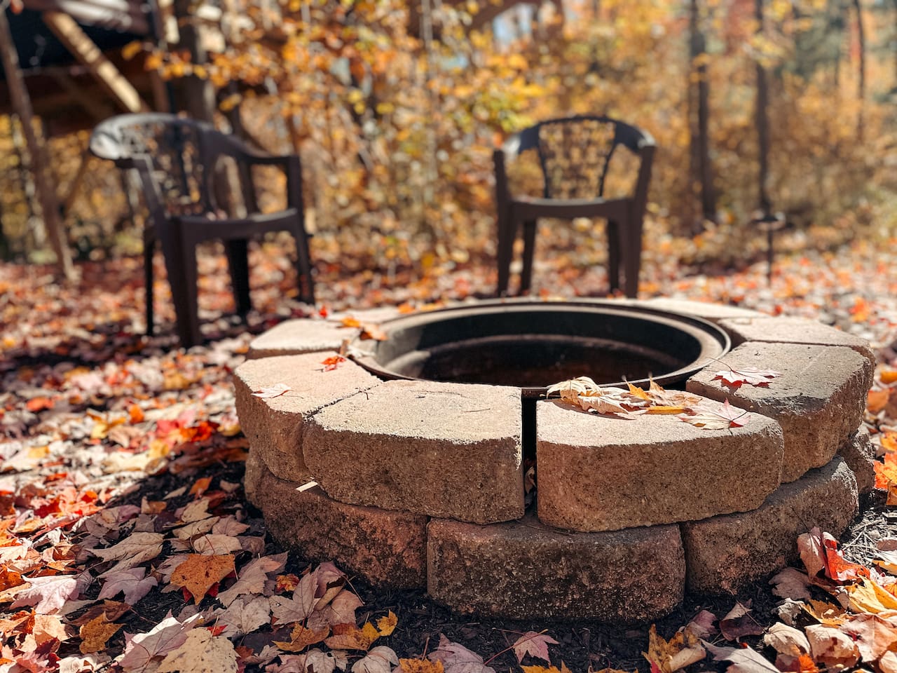 Cozy fire pit, with plastic chairs, perfect for relaxing evenings under the stars. Ample seating for everyone.
