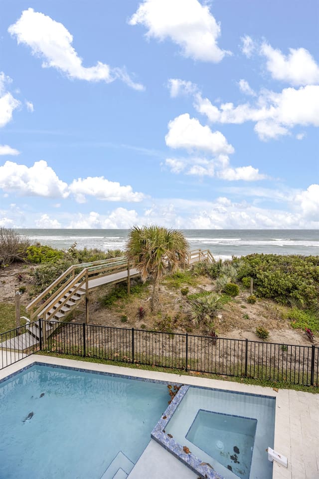 Enjoy the exterior of the house with a sparkling swimming pool, offering a beautiful view of the ocean and a charming bridge leading directly to the sea, creating a perfect blend of tranquility and coastal beauty
