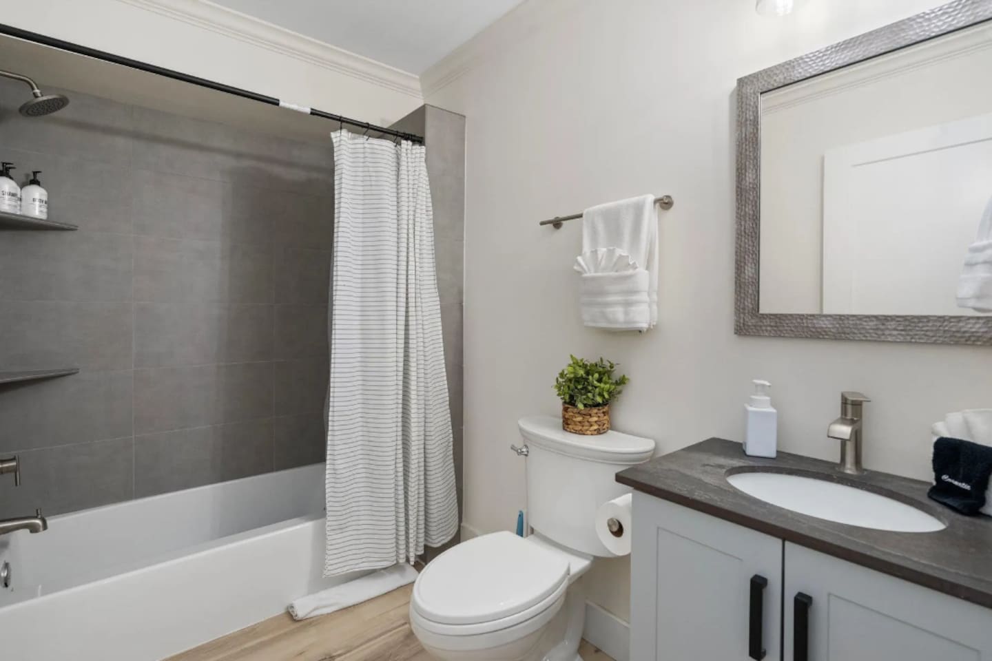 A classic tub-shower combo makes this bathroom easy for families, with fresh towels and a tidy vanity keeping everything feeling well cared for.