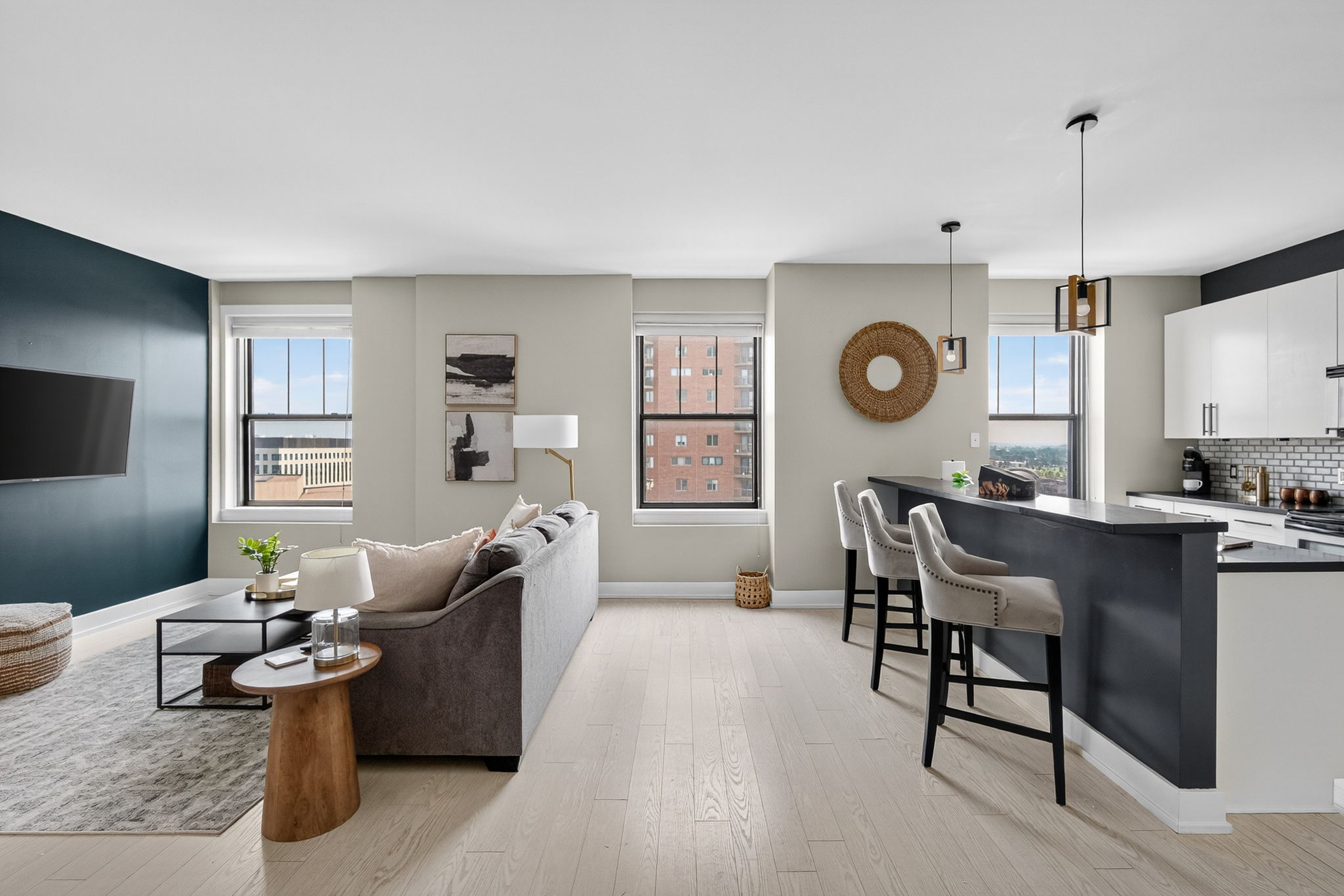 Open-concept living and kitchen area with tons of natural light, a leather sofa, and modern finishes—ideal for relaxing or entertaining.